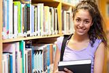 Smiling female student posing with a book