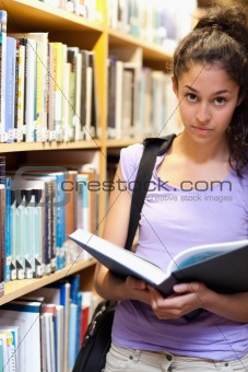Portrait of a serious female student holding a book