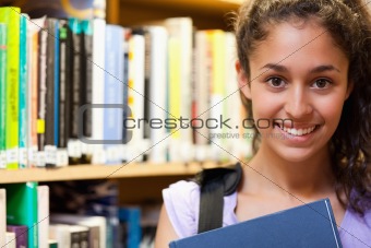 Happy female student holding a book