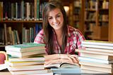 Smiling student having a lot to read