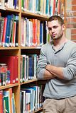 Portrait of a male student leaning on a shelf