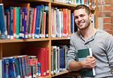 Smiling male student holding a book