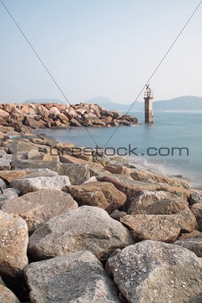 Lighthouse on a Rocky Breakwall: A small lighthouse warns of a rough shoreline. 