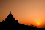 mosque in desert with camels silhouette