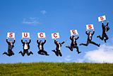 happy businessman holding success text  and jumping on the green field