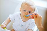 Eat smeared pretty baby eating from spoon