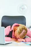Tired business woman sleeping on office desk
