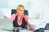 Confused business woman at office desk

