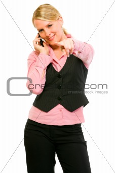 Smiling business woman talking on cell phone and pointing on you
