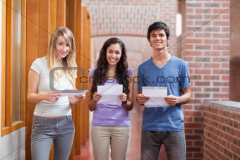 Smiling students holding a piece of paper