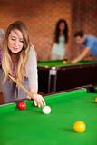 Portrait of a cute woman playing snooker