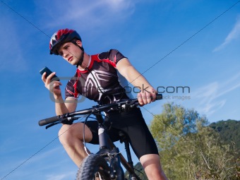 young man with telephone riding mountain bike 