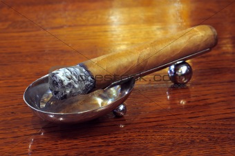 Cigar on a stand on a wooden background