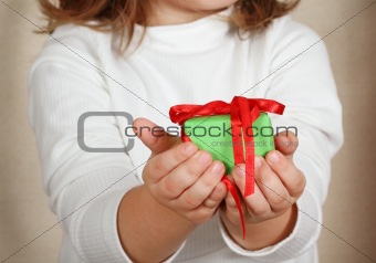 Little hands of the child holding Christmas present.