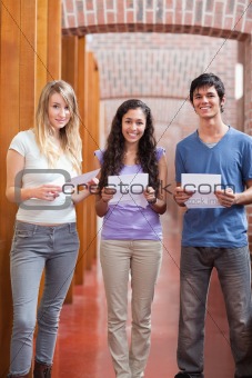 Portrait of smiling students holding a piece of paper