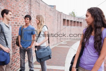 Lonely student looking at her classmates talking