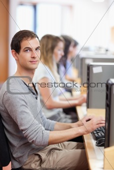 Portrait of a male student posing with a computer