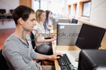 Smiling male student posing with a computer