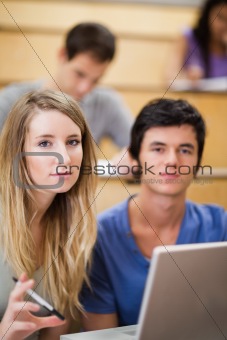 Portrait of students posing with a laptop