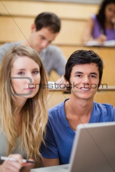 Portrait of students posing with a laptop