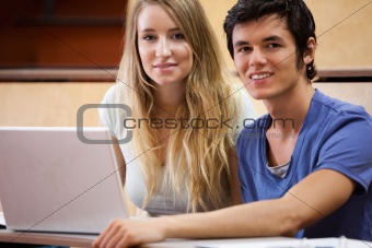 Young students posing with a laptop