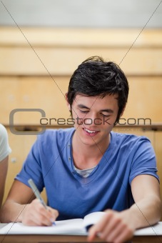 Portrait of a handsome young student taking notes