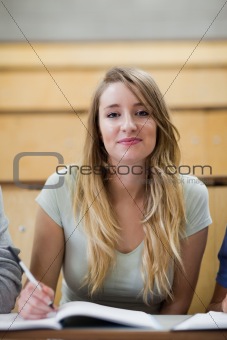 Portrait of a cute student holding a pen