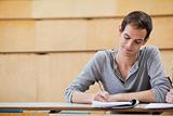 Portrait of a male student writing on a notepad