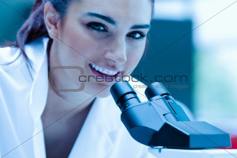Young scientist posing with a microscope