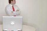 businessman standing behind laptop