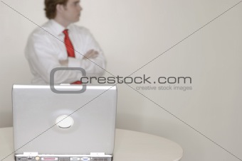 businessman standing behind laptop