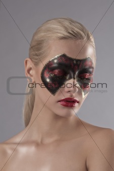 pretty blonde with carnival mask painted on face