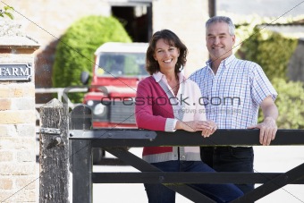 Farmer And Wife Looking Over Farm Gate
