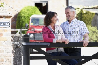Farmer And Wife Looking Over Farm Gate