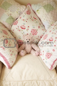 Chair with cushions and teddy bear