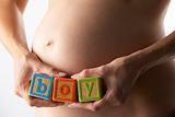 Pregnant Woman Holding Blocks Spelling "Boy"