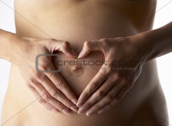 Detail Of Pregnant Woman Forming Heart Shape With Hands