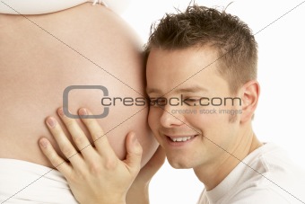 Man Listening To Pregnant Woman's Stomach