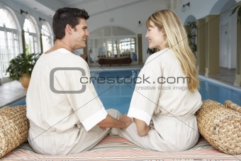 Young Couple Relaxing By Swimming Pool