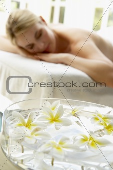 Woman On Massage Table With Flowers In Foreground