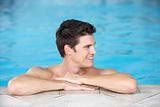 Young Man Resting On Edge Of Swimming Pool