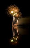 Colorful fireworks on black sky background with water reflection