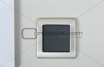 light switch on the wall with grey button on silver frame