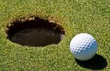 Golf ball next to a hole