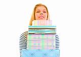 Pretty teen girl holding stack of present boxes

