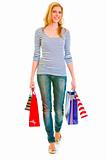 Smiling teen girl with shopping bags making step
