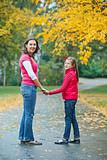 Cute girl with her mother walking in park