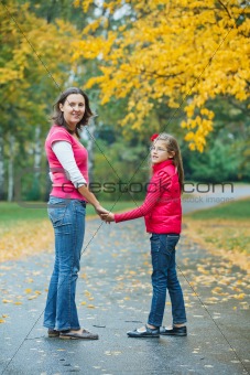 Cute girl with her mother walking in park