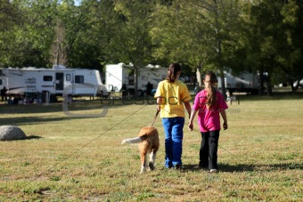 Girls Walking a Dog While Camping 