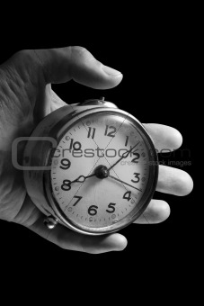 Hand and old Alarm Clock